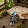 Mushroom Cottage Pendant Necklace with Dimensional Relief, Floral and Leaf Details, Blue Teardrop Dangle, and Vintage-Inspired Alloy Finish