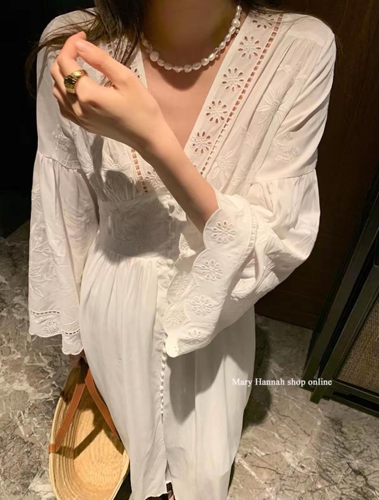 Robe blanche à manches longues et broderie ajourée pour les vacances à l'île ou à la plage