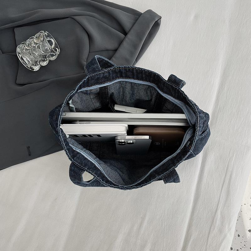 En denimväska med stor kapacitet En avslappnad och mångsidig toteväska för skola, pendling och en axelväska