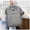 New style mommy bag with large capacity, featuring a patchwork design, contrasting colors, and a versatile, fashionable look. It’s a waterproof