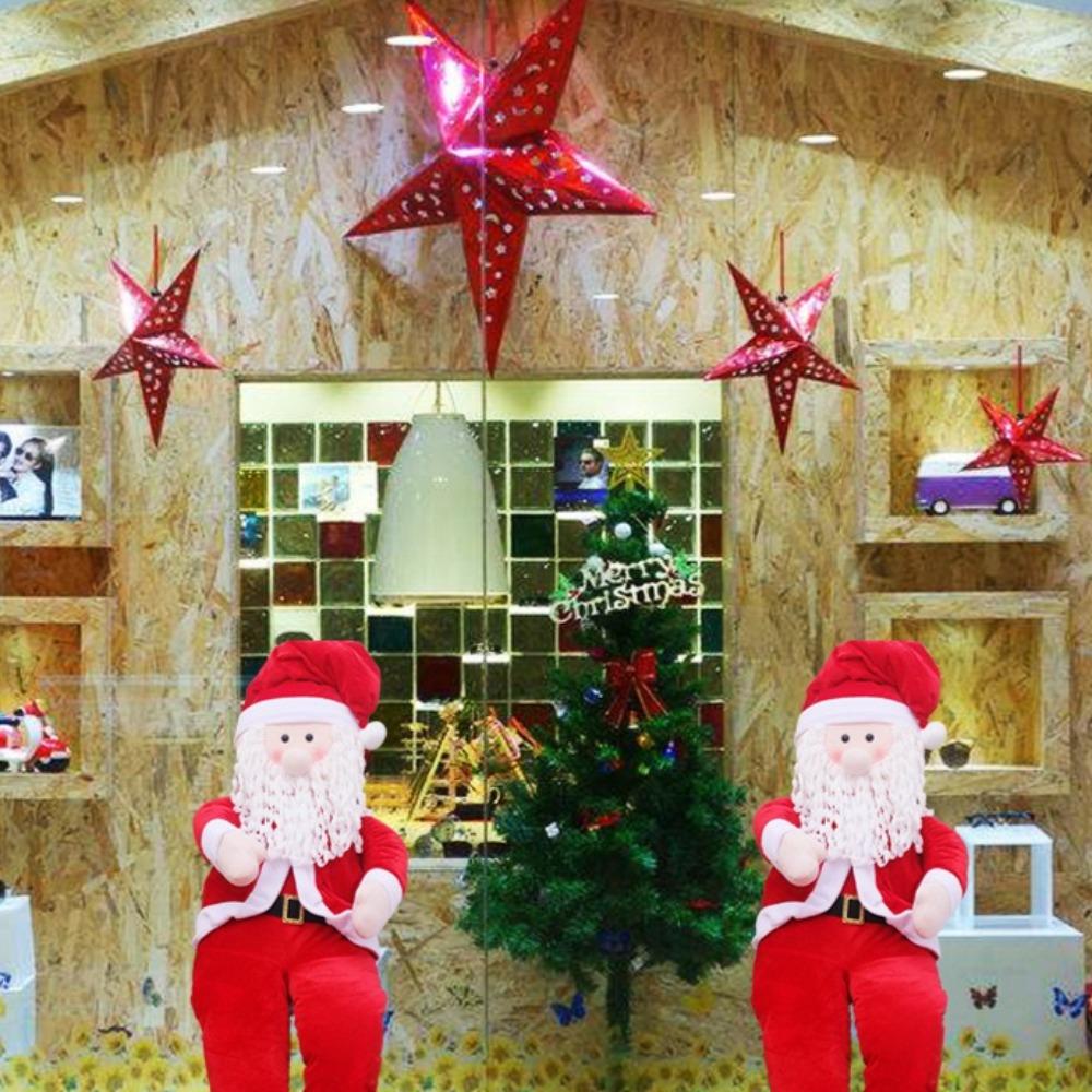 Rekwizyty Świętego Mikołaja, wózek z reniferami w pozycji siedzącej, Święty Mikołaj niosący paczkę z prezentami, świąteczna dekoracja okienna scena