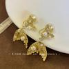 Gold fishtail pearl ear clips without ear piercings, high-end sense niche unique earrings, long mosquito coil disc earrings.