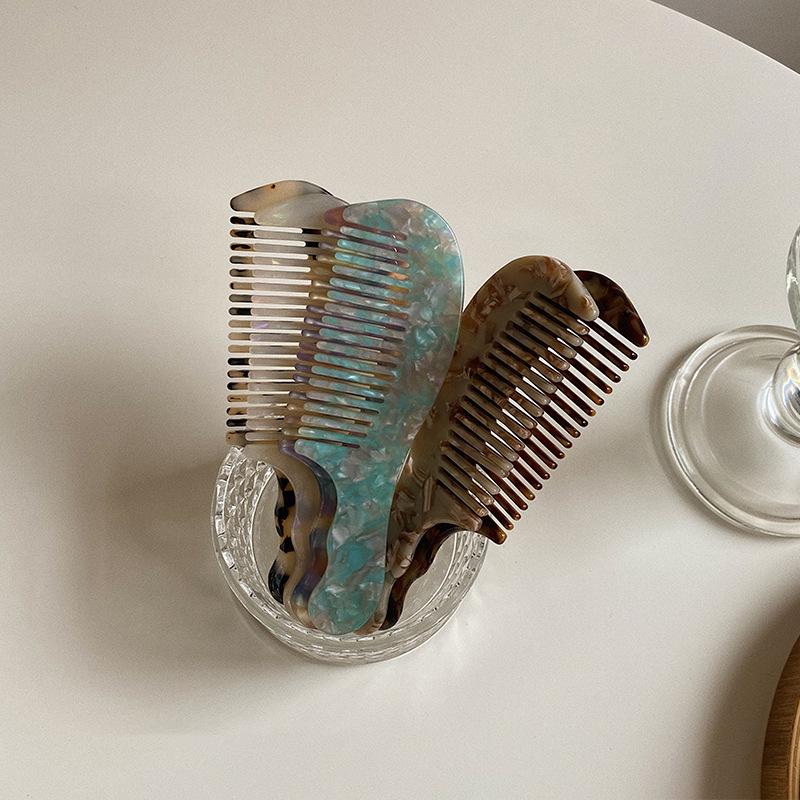 Elegant and compact tortoise shell acetate hair comb for easy portability.