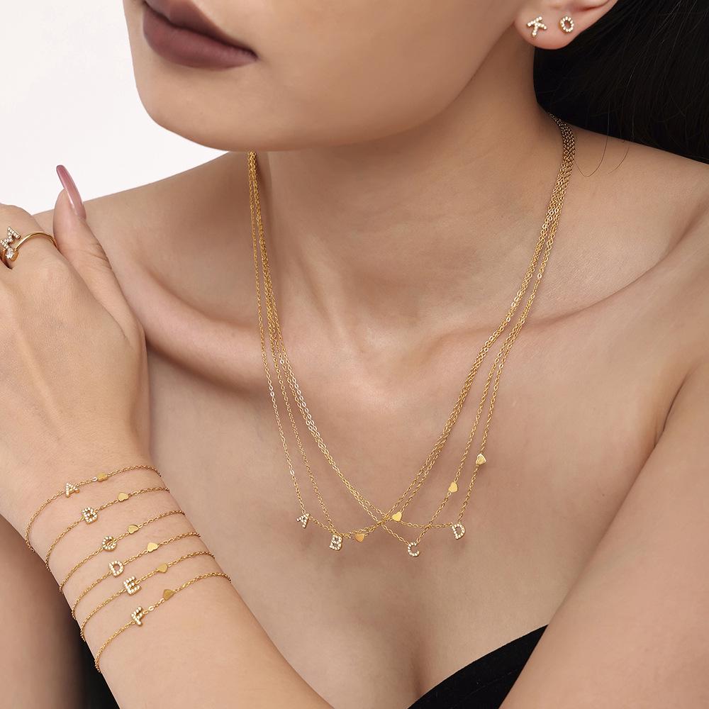 Oumeika Titanium Steel Jewelry Set: 26 Zircon-Inlaid Letters, PVD Gold-Plated Necklace, Bracelet, Earrings, and Ring.