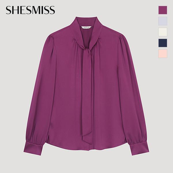  Ona ma na sobie bluzkę z guzikami i wiązaniem pod szyją Swwblo11020