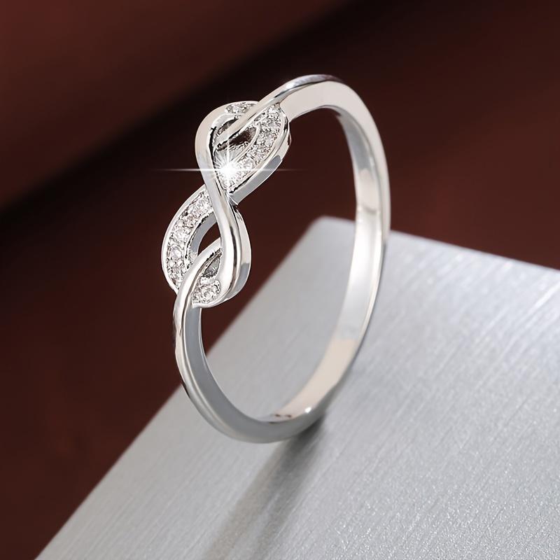 

Трендовое кольцо, выполненное в форме восьмерки с инкрустацией циркониями. Подходит для женщин серебряный