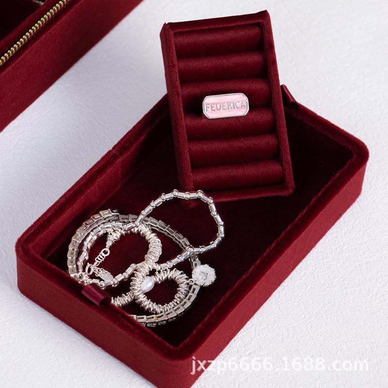 Czerwone aksamitne pudełko podróżne na biżuterię ze złotymi akcentami