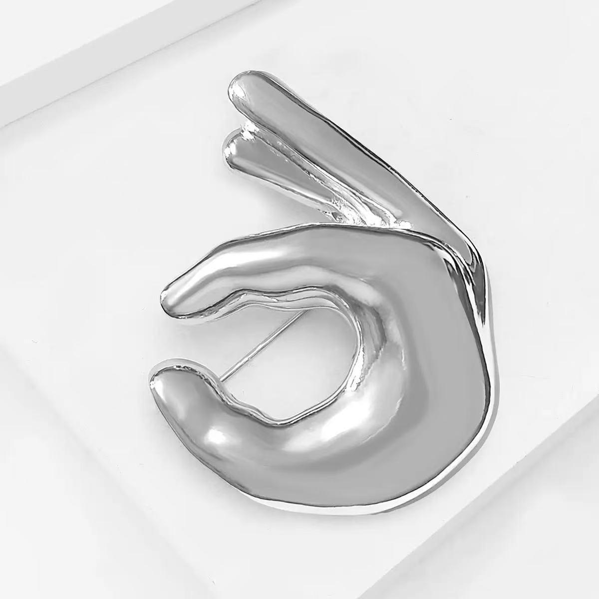 

Ретро брошь с жестом руки ОК: Текстура полированного металла, Стильный значок для пар, Элегантный аксессуар для одежды.