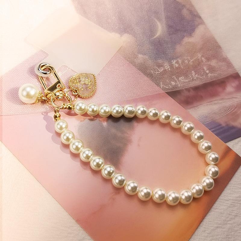 

Mobile phone lanyard, portable Chinese style retro pearl bracelet, short wrist rope, handmade beaded round bead keychain hanging. Limited edition pink pearl chain clasp