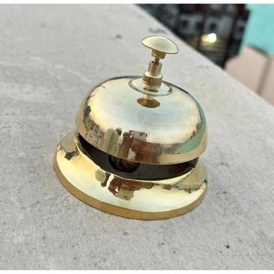 Mosazný zvonek na stůl Rezonující elegance Nadčasový půvab lesklého masivního mosazného zvonu na stůl s klasickým tradičním uměleckým dílem