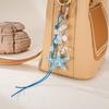 Handmade beaded woven rope pendant with colorful sequins and star-shaped design for mobile phone decoration.