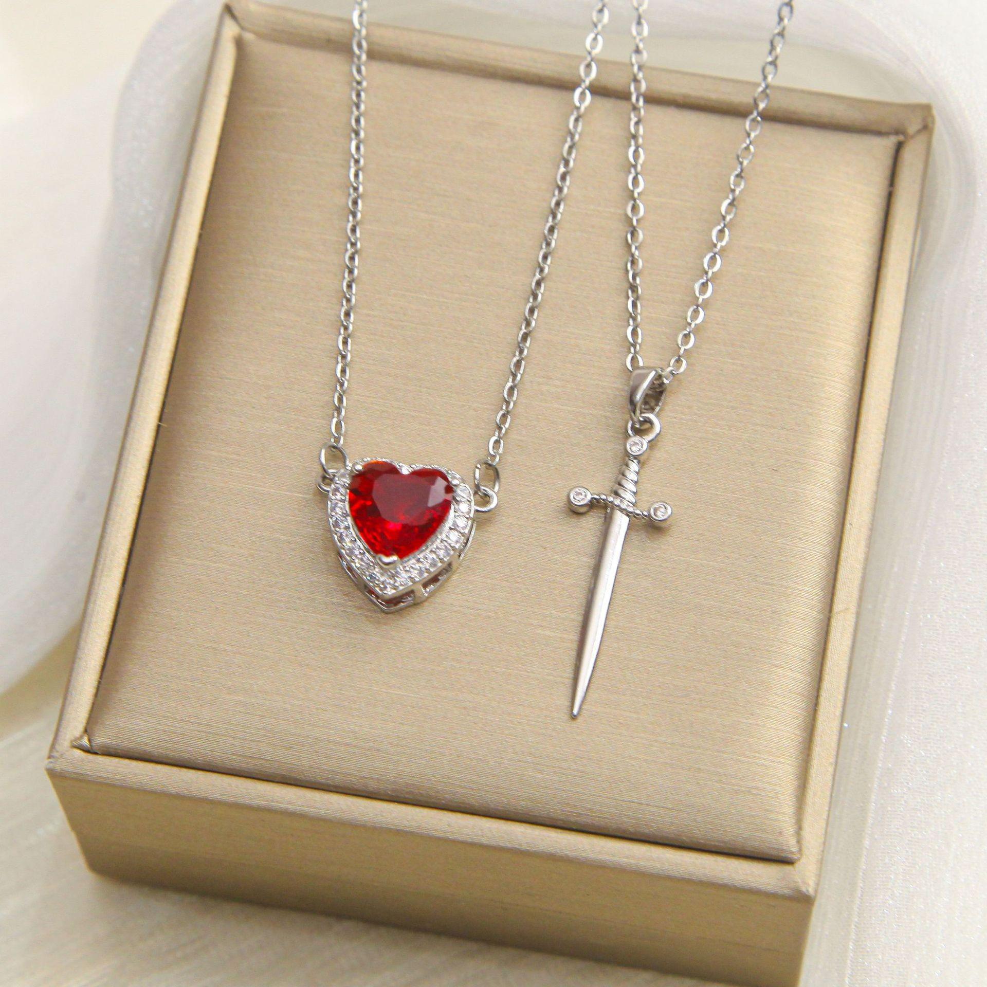 

Titanium Steel Sword & Red Heart Necklace Set with Micro-Set Cubic Zirconia Arrow and Layered Clavicle Chain.