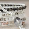 Handgefertigtes Perlenarmband mit 5 Strängen aus weißem Rindslederband und schwarzen und weißen Achat-Scheiben.