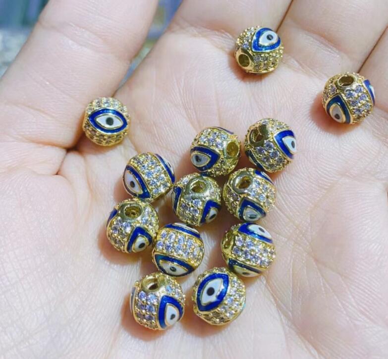 

Круглые бусины «глаз дьявола» с микропаве из цирконов, медь с заполнением золотом 14 карат, эпоксидная смола 8mm