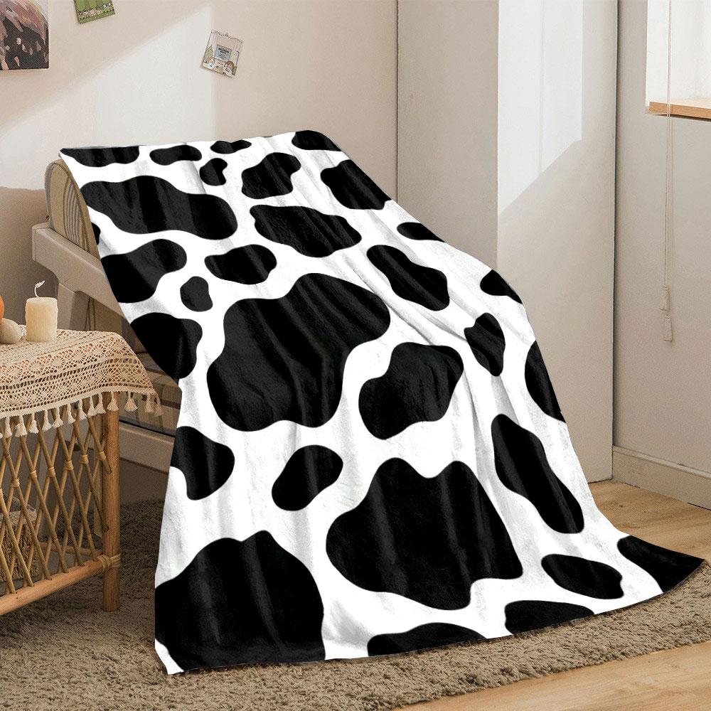 Black irregular spots on a white background resembling a cow print. for all seasons blanket lunch break throw gift