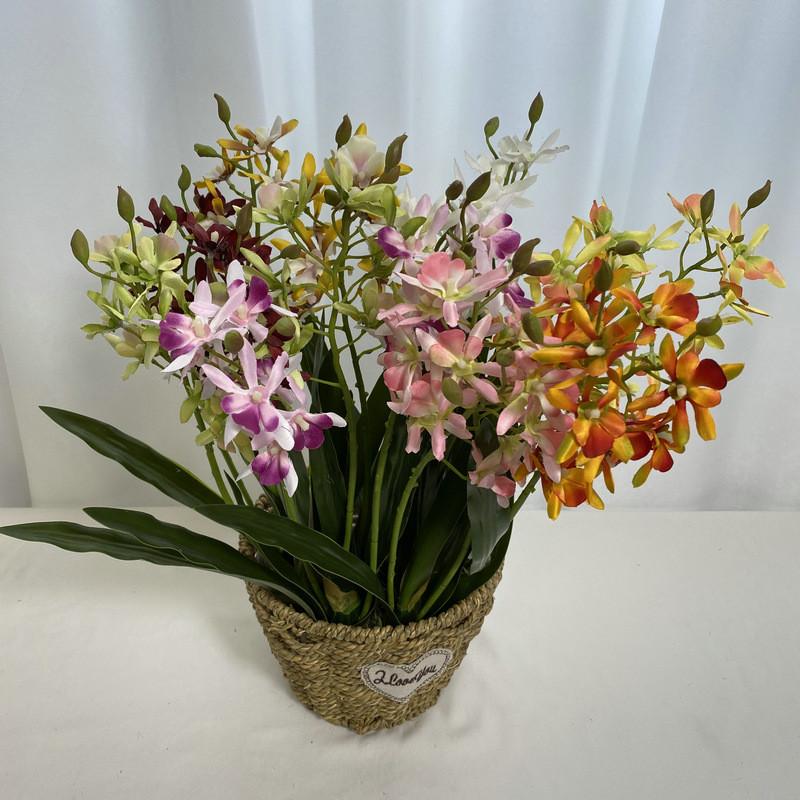 Realistische Seiden-Dendrobium-Orchidee mit Blättern für Blumengesteck auf dem Esstisch