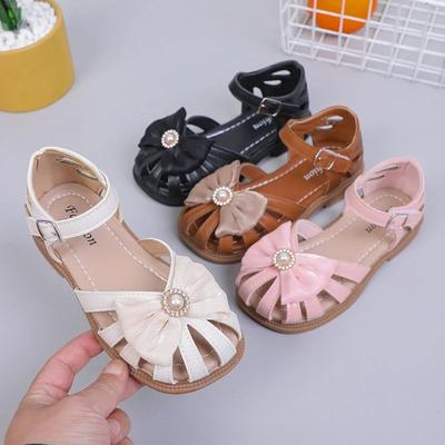 Flickor Sandaler Sommar Ny PU Prinsessa Ihåliga Täckta Tår Barn Mode Rosett med Stor Pärla Mjuka Enkla Barn Fritidsskor