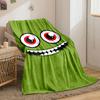 A green face with large red eyes and a wide, toothy grin. for all seasons blanket lunch break throw gift
