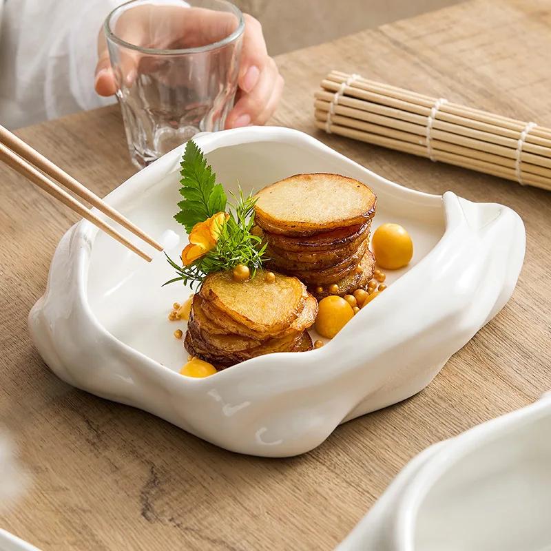 Artistic conception dishes are arranged irregularly. The hotel restaurant features domestic ceramic tableware for cold dishes.