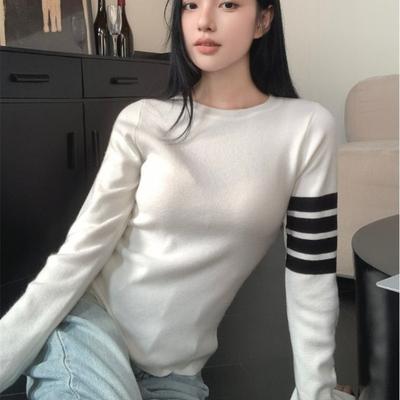 Ein Nischen-gestreifter langärmeliger Strickpullover ist weich und figurschmeichelnd für zierliche Frauen im frühen Herbst