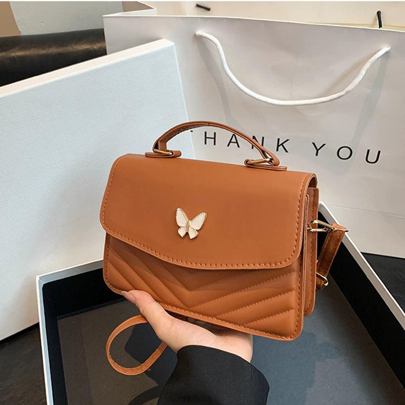Schicke Schwarze gesteppte Umhängetasche mit zarter Schmetterlingsverzierung, Stilvolle Handtasche mit oberem Griff, Trendige Mini-Tasche für Alltagsoutfits