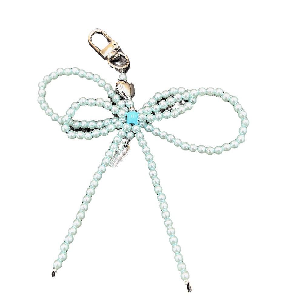 Fashionable Korean-inspired blogger-style large pearl bow mobile phone pendant key chain with heart design.
