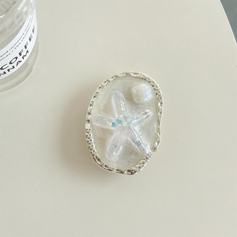 

Creative Oval Epoxy Starfish Mobile Phone Airbag Bracket Wind Desktop Bracket Watching Drama Lazy Portable