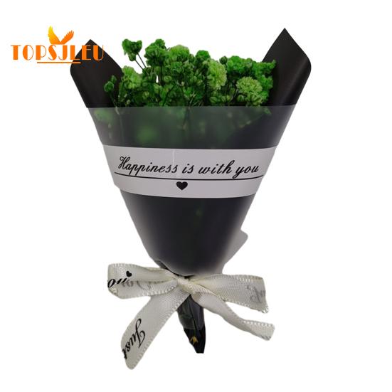 In Papier eingewickelte, mit getrockneten Blumen duftende Schleierkrautblüten, Schleife mit Buchstabenmuster, langanhaltende, lebendige Farbe, Blumenstrauß als Geschenk zum Valentinstag