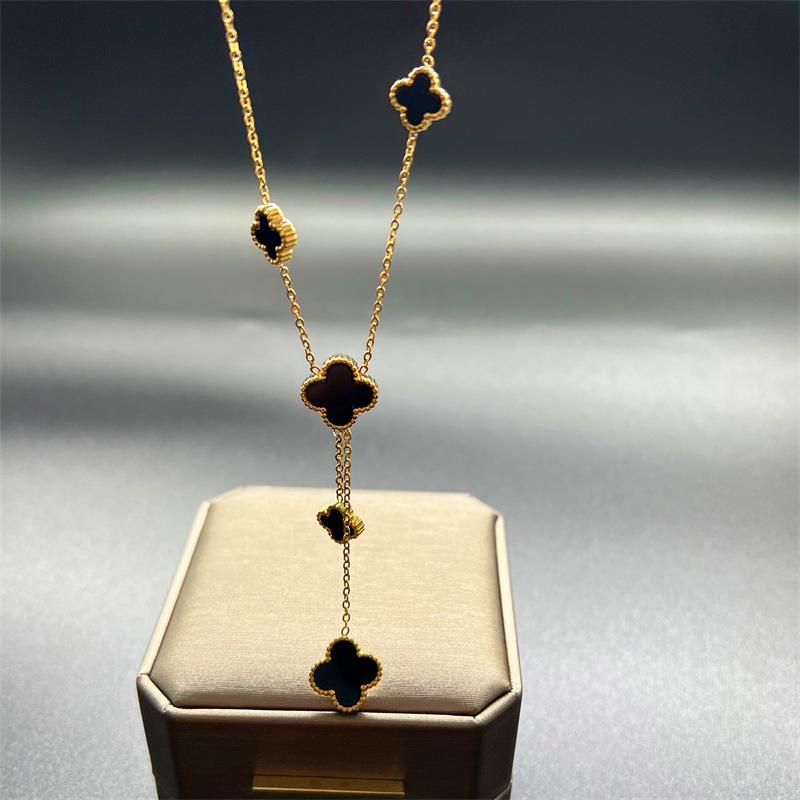 European & American Trendy Hollow Four-Leaf Clover Necklace with Black Shell Tassel Pendant.