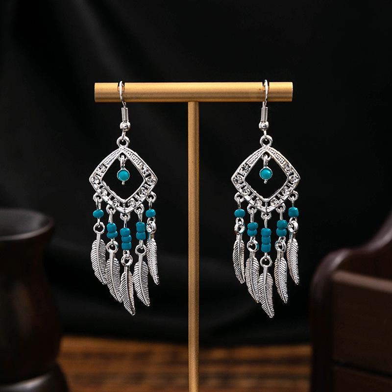 Boucles d'oreilles pendantes à pompons de plumes ethniques - Style argent Miao imitation, article touristique populaire, design mignon de haricot.