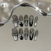 Skin-brightening grey press-on nails featuring detachable black Chrome Hearts-style crosses; entirely handmade.