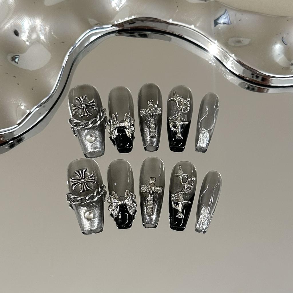 Skin-brightening grey press-on nails featuring detachable black Chrome Hearts-style crosses; entirely handmade.
