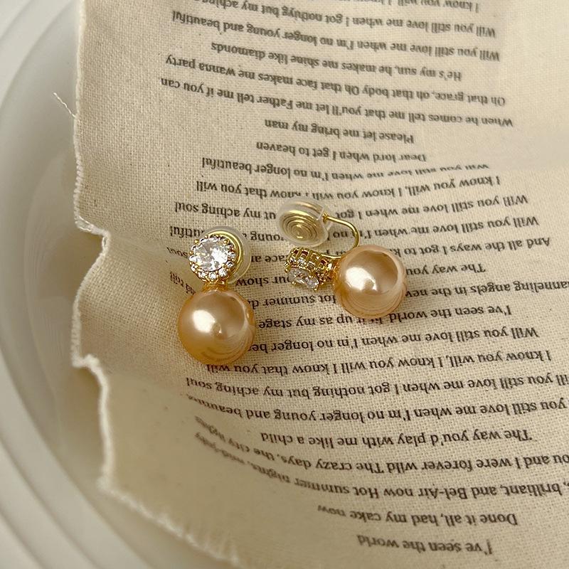 

Elegant gray pearl mosquito coil disc ear clips without ear piercings, women s micro-inlaid zircon stud earrings, fashionable light luxury earrings.