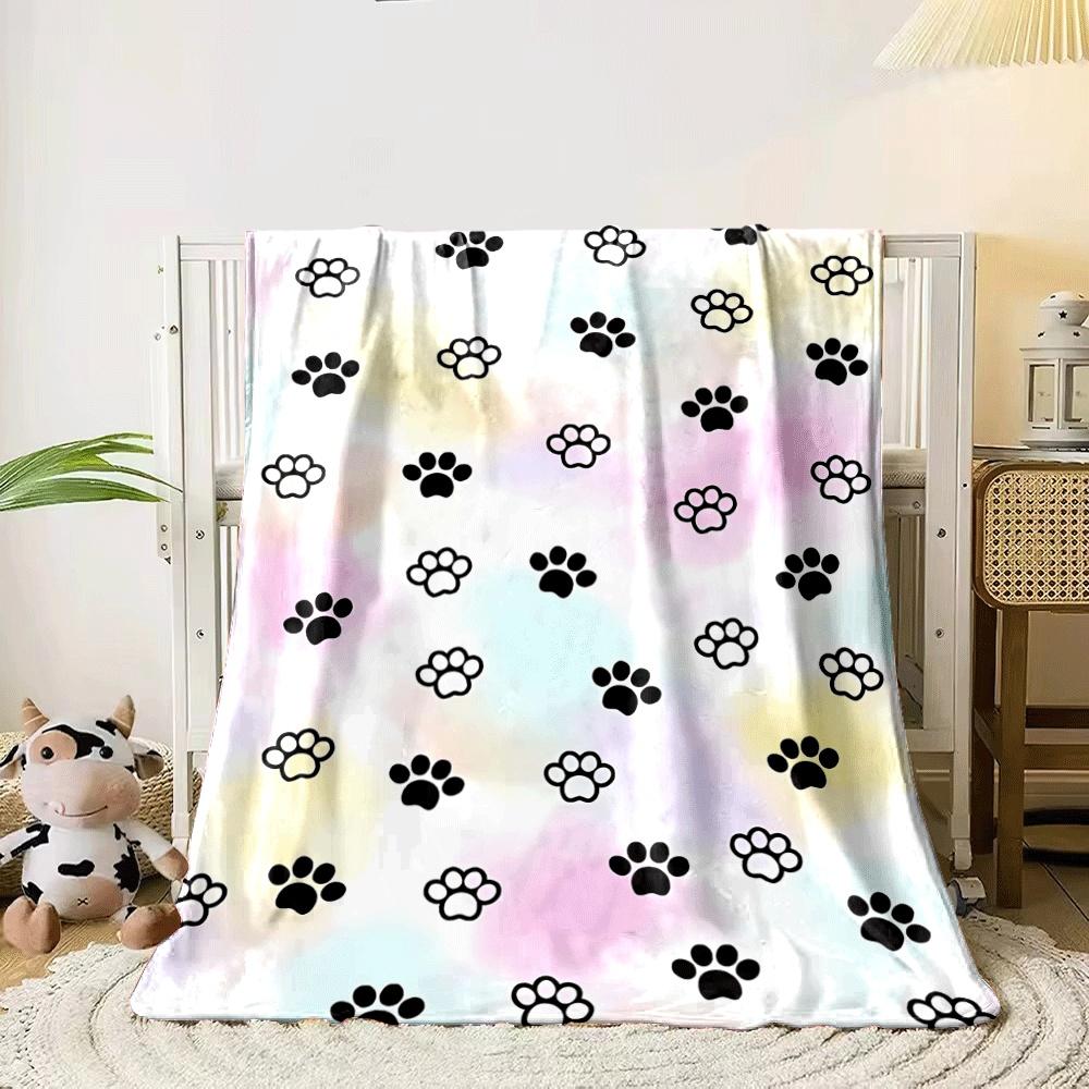 Black and white paw prints scattered over a pastel-colored background. for all seasons blanket lunch break throw gift 80cm x 120cm