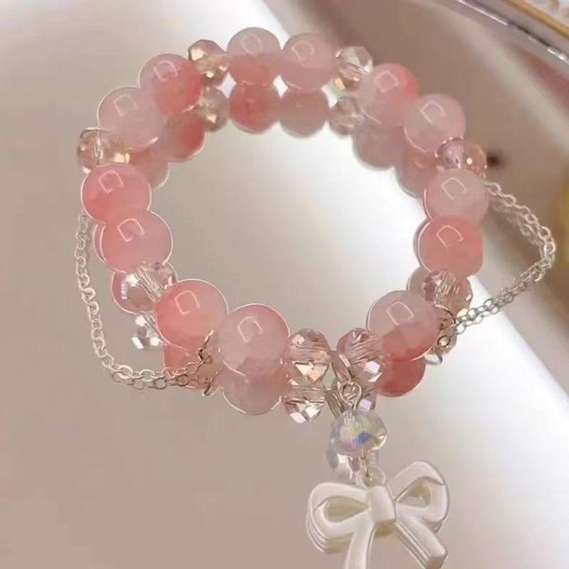 Vierteiliges neues Pfirsichpuder-Glasperlenarmband, frisches und süßes Temperament, weißes Schleifenarmband kostenlos dazu.