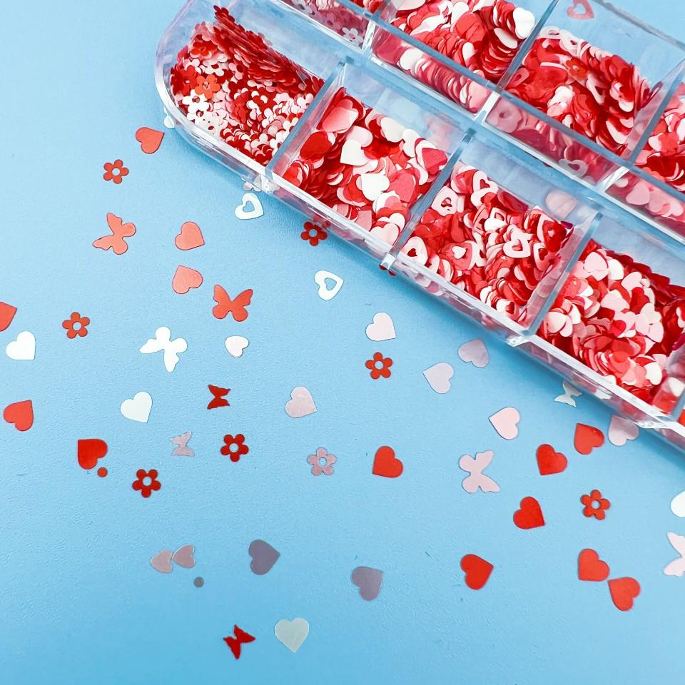 12-Grid Valentine's Day Nail Art Box: Pink Butterfly, Flower, Heart, and Mixed Sequins in Pink, White, and Red.