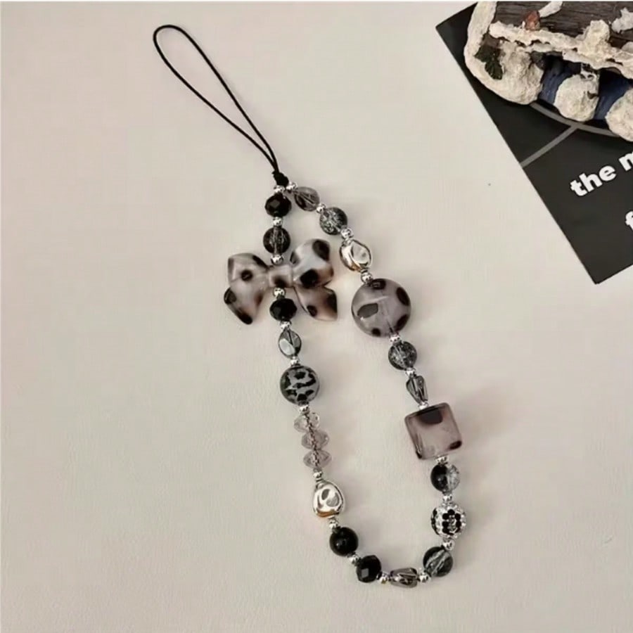 

A fashionable mobile phone lanyard adorned with leopard print bow and bead decorations, used as an anti lost phone lanyard Polyester Fiber