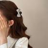 The Princess with The Checkered Bow Accessory Has A Chic Patterned Beak Hairpin At The Back of Her Head and A Hairclip.