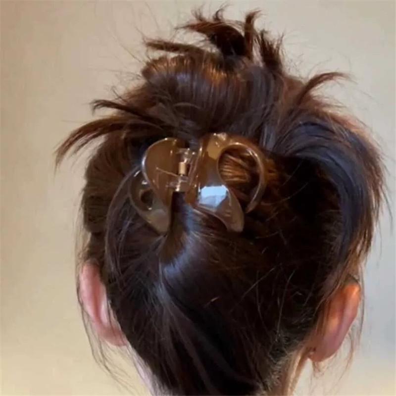 Fermagli per Capelli da Donna dall'Aspetto Sofisticato, con uno Chignon Basso con Capelli Spaziati sul Retro, e un Accessorio per Capelli a Forma di Squalo.