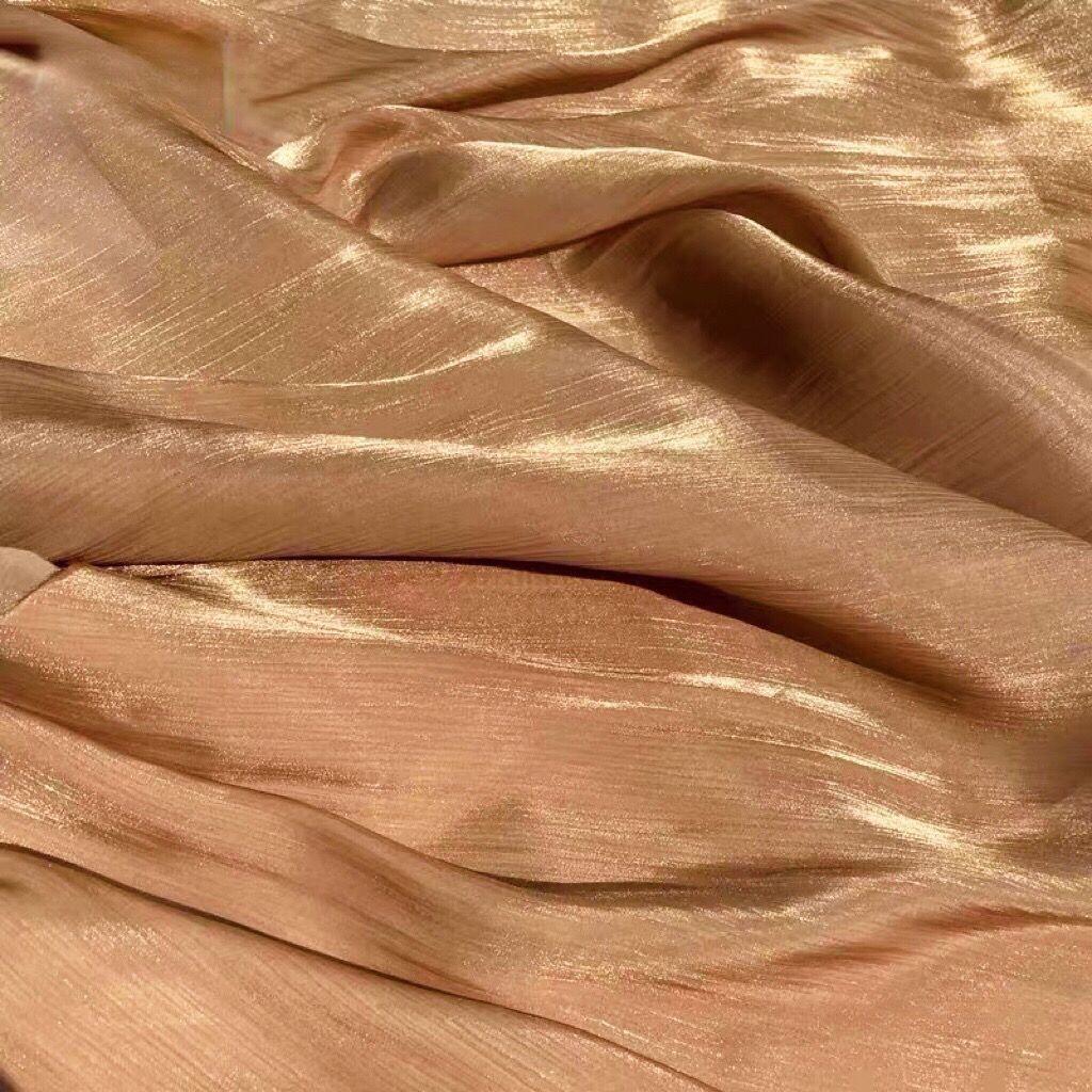 Soft shiny creased organza fabric with a smooth texture suitable for wedding dresses formal gowns and designer clothing fabrics