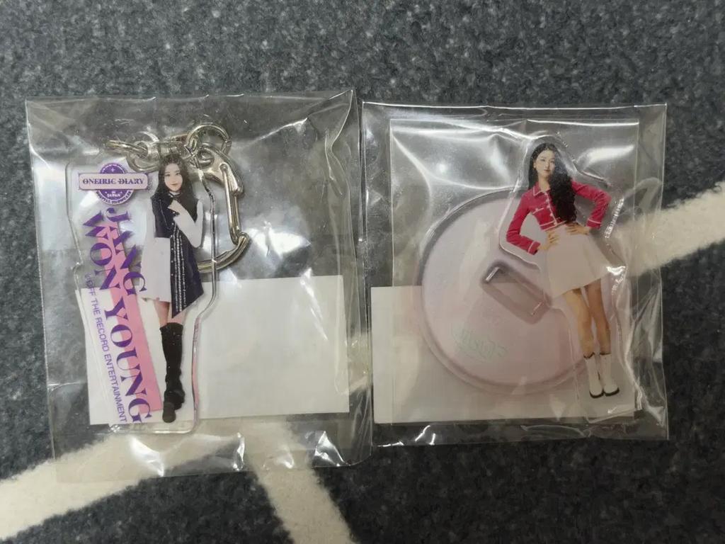 Jang Wonyoung merchandise, including nameplates, acrylic stands, keyrings, and other goods for sale.