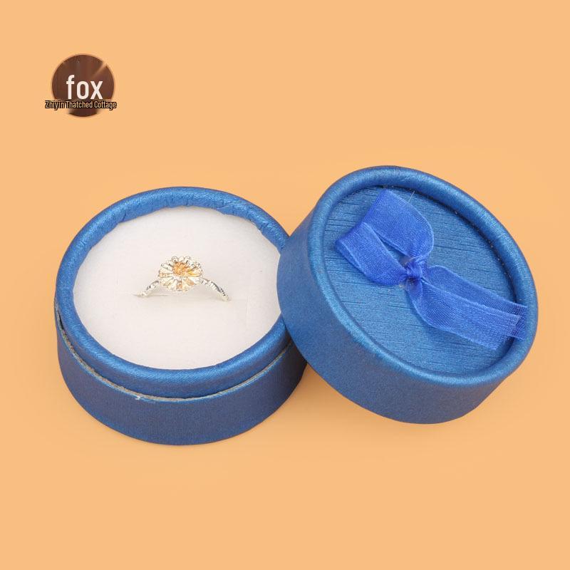 

Маленькая круглая шкатулка с бантиком для колец и серег