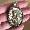 A vintage-style angel fairy round pendant necklace with a dreamy flower fairy time gemstone design, suitable for both men and women.