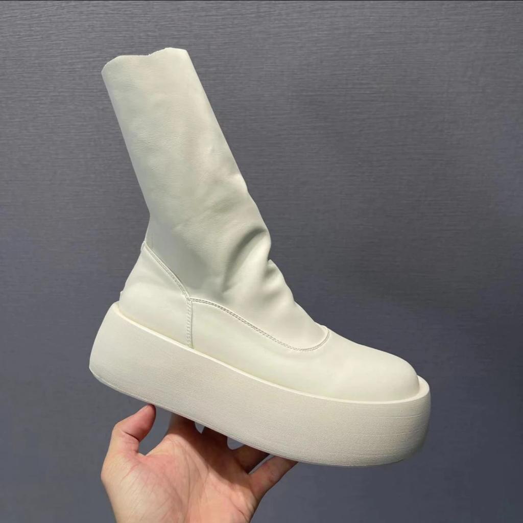 Modelka na přehlídkovém mole v minimalistickém stylu podzim 2025, cigaretové kozačky, na jeden pedál, tenké kozačky mohou být slané i sladké, korejská verze elastických kozaček na silné podrážce