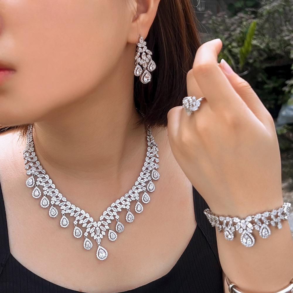 Ensemble quatre pièces de luxe Zircon Mariage Collier Boucles d'oreilles Bracelet Bague Robe de mariée Robe Accessoires de dîner Femmes