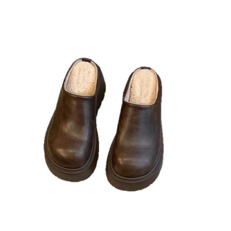 Persoana mică mărește înălțimea capului genții și a papucilor jumătate, și poartă noii papuci Birkenstocks termici din catifea cu talpă groasă toamna.