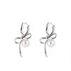 Silver Bow and Pearl Earrings: Elegant, Luxurious, Versatile Women's Accessories