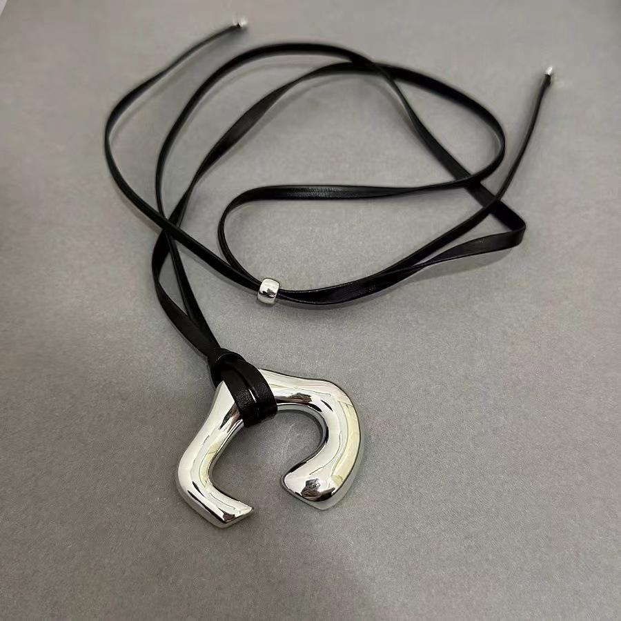 

Коричневое кожаное колье-шнурок с серебряной абстрактной подвеской в виде человеческого тела – осенне-зимняя легкая роскошь, ключичная цепочка чёрный