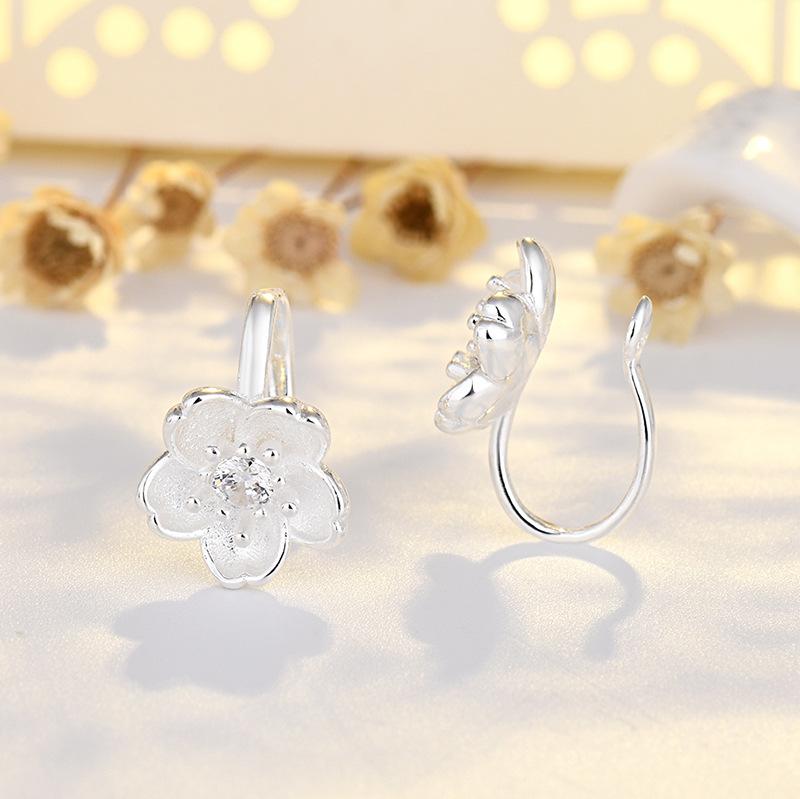 Молодая девушка со свежими бриллиантами, инкрустированными в уши без пирсинга, серьги в виде цветков вишни, цветы, серьги в виде цветков персика