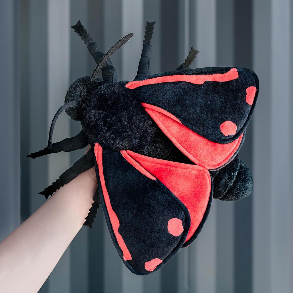 A small stuffed cinnabar moth with blue wings